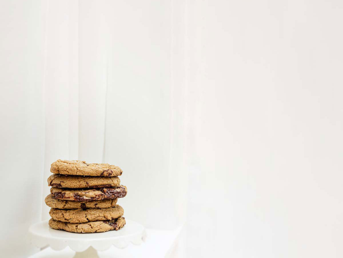 a stack of chocolate chip cookies on a white pedestal